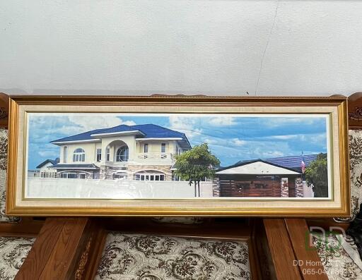 Framed photo of a house placed against a wall