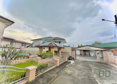 Front view of a residential property with a yard and a driveway