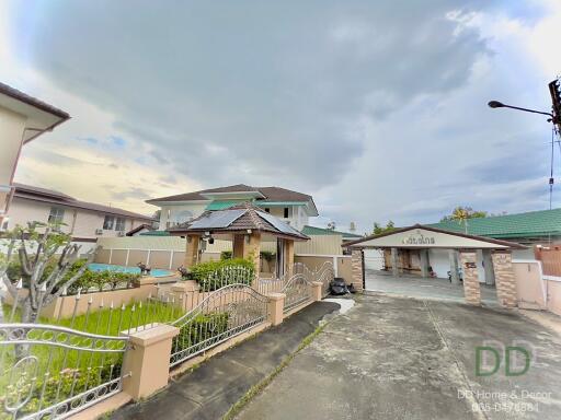 Front view of a residential property with a yard and a driveway