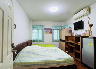 Bedroom with bed, TV, air conditioner, and furniture