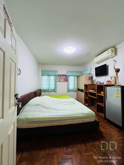Bedroom with bed, TV, air conditioner, and furniture