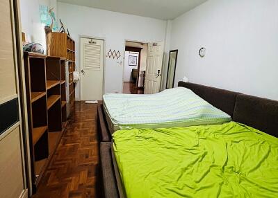 Spacious bedroom with bookshelf and comfortable bedding