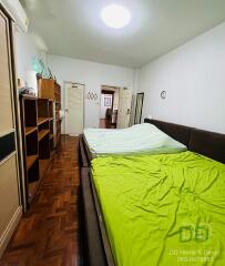 Spacious bedroom with bookshelf and comfortable bedding