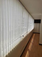 Bright corridor with large windows and vertical blinds