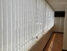 Bright corridor with large windows and vertical blinds