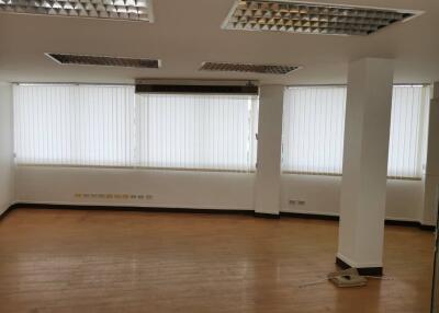 Empty living room with large windows and blinds