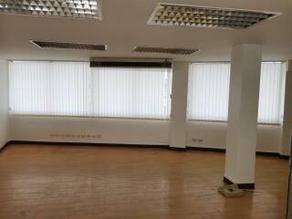 Empty living room with large windows and blinds