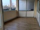 empty room with large windows and wood flooring