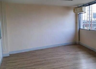 Empty room with wooden flooring and large windows