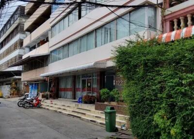 Exterior view of a multi-story residential building with balconies and entrance