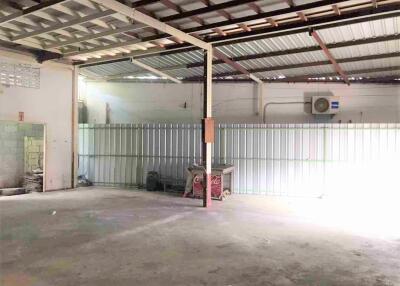 Empty spacious industrial building with metal roof and equipment