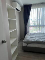 Bedroom with simple furnishings and an air conditioner