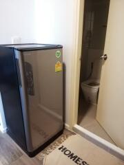 Compact kitchen area with mini-fridge and adjacent bathroom