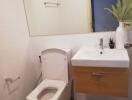 Modern bathroom with white toilet, wall-mounted sink, and decorative plants