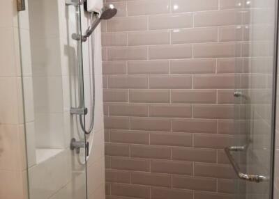 Modern shower area with glass doors and wall tiles