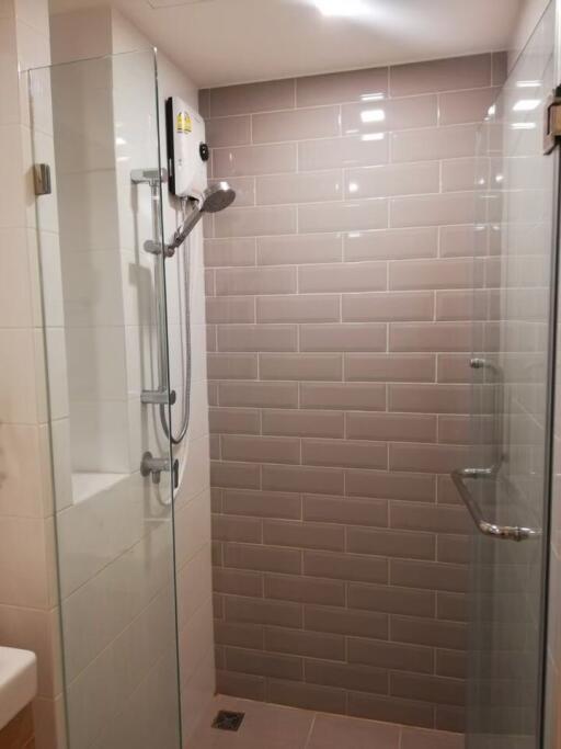 Modern shower area with glass doors and wall tiles