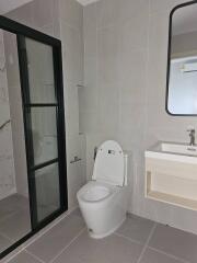 Modern bathroom with toilet, sink, and shower area