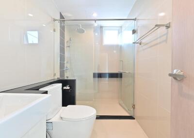 Modern bathroom with glass shower door and white fixtures