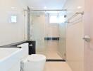 Modern bathroom with glass shower door and white fixtures