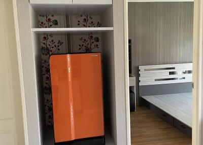 Bedroom with a closet and a bright orange refrigerator