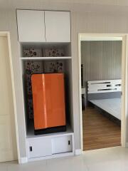 Bedroom with a closet and a bright orange refrigerator