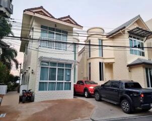 Exterior view of two modern houses with parked vehicles