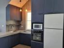 Modern kitchen with blue cabinets and appliances