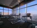 Modern fitness center with treadmills and city view