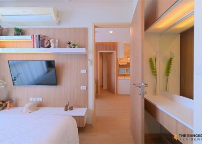 modern bedroom with wooden wall paneling and mounted TV