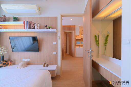 modern bedroom with wooden wall paneling and mounted TV