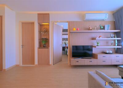 Modern living room with built-in shelves and TV unit.