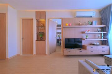 Modern living room with built-in shelves and TV unit.