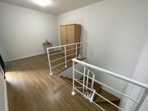 Second floor landing area with wooden flooring and white railing