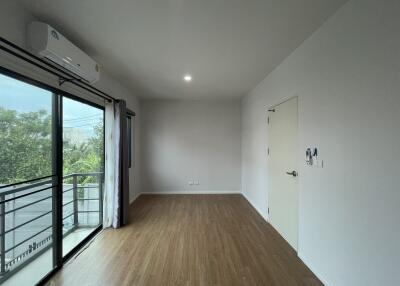 empty bedroom with wooden flooring and large window