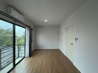 empty bedroom with wooden flooring and large window