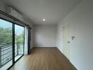 empty bedroom with wooden flooring and large window