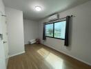 Minimalist bedroom with wooden flooring, window and AC unit