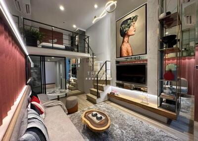 Elegant and modern main living area with loft, large art piece, and stylish furnishings