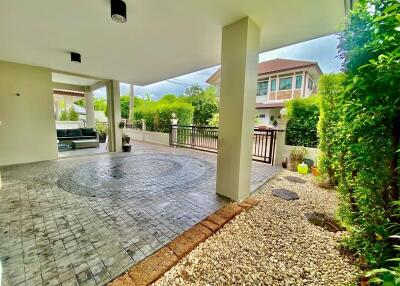 Modern outdoor patio with tiled flooring and adjacent garden