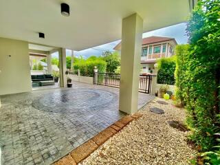 Modern outdoor patio with tiled flooring and adjacent garden