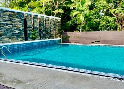 Outdoor swimming pool with lush greenery