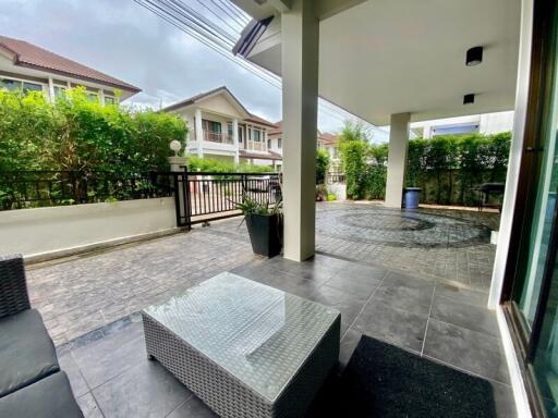 Outdoor patio area with tile flooring and seating