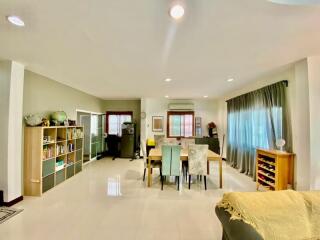 Spacious main living area with dining table and bookshelf