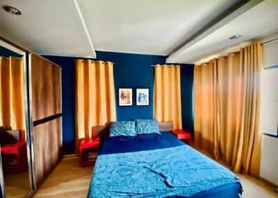 Modern bedroom with blue walls and orange curtains