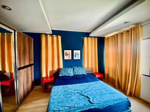 Modern bedroom with blue walls and orange curtains