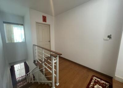 Spacious upstairs hallway with wooden flooring and staircase