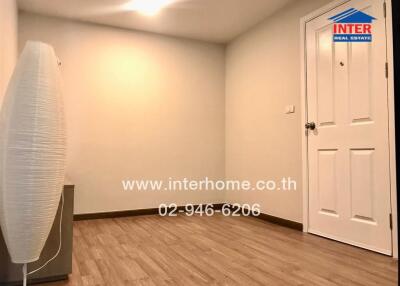 Empty room with hardwood floor and standing lamp