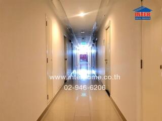 Well-lit corridor in building with doors on either side