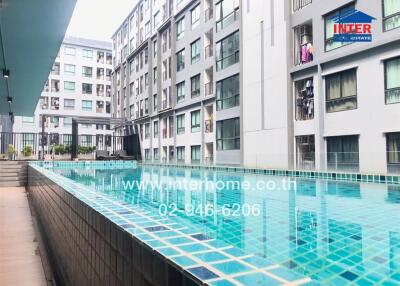 Outdoor view of residential apartment complex featuring a swimming pool