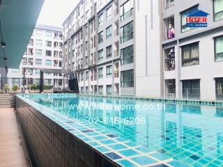Outdoor view of residential apartment complex featuring a swimming pool